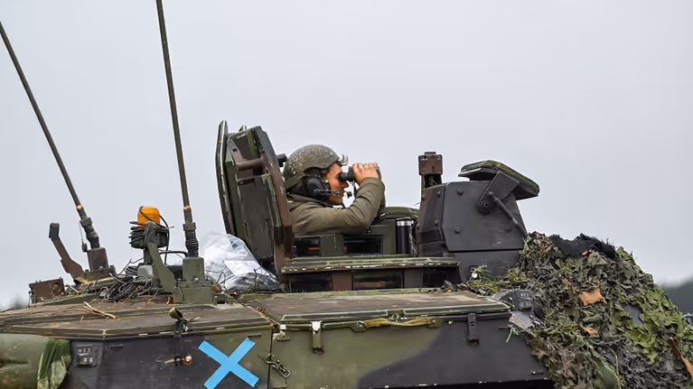 Militair in tank kijkt door verrekijker